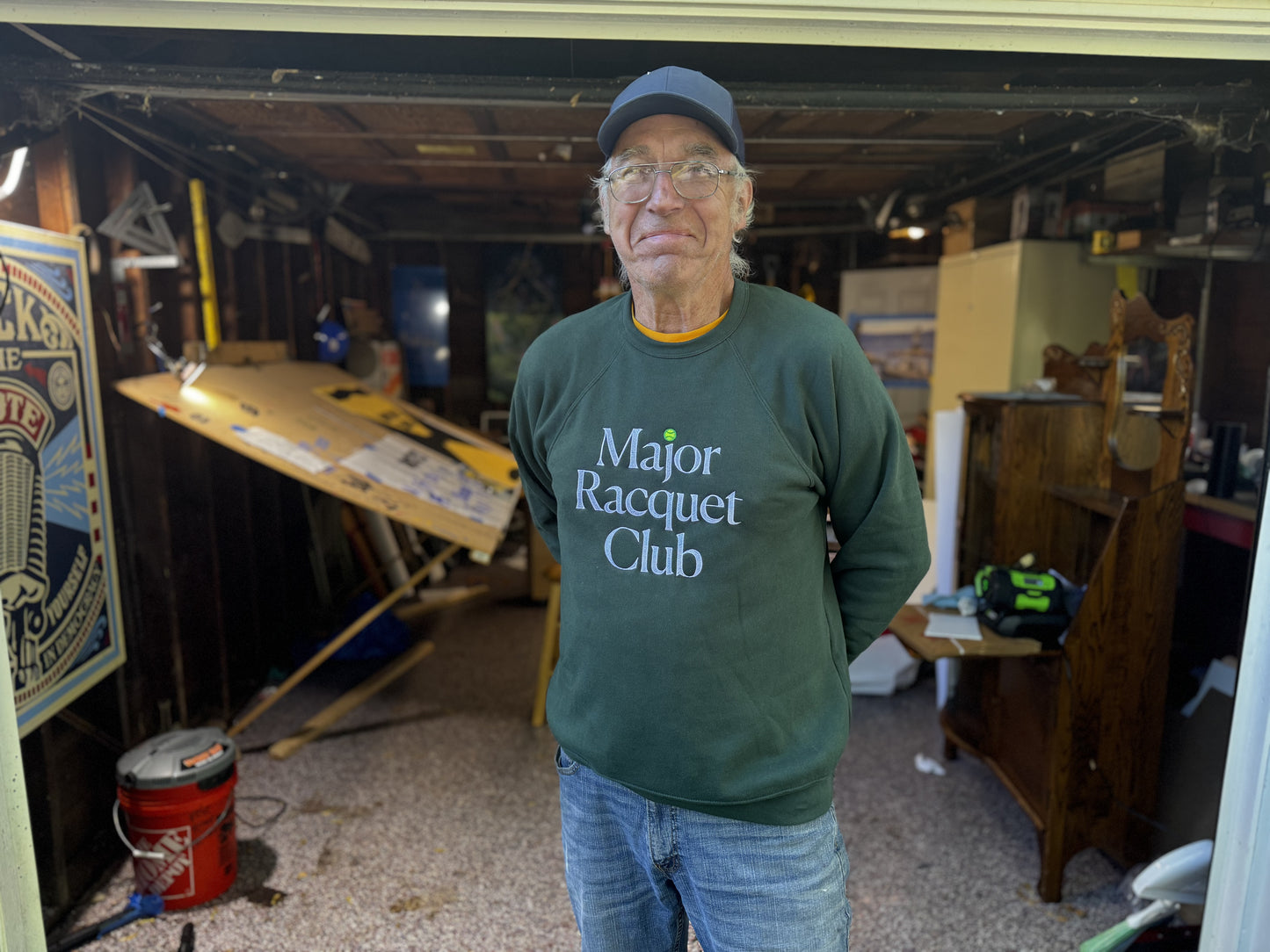 Ches Perry of Right Way Signs wearing a green 'Major Racquet Club' sweatshirt